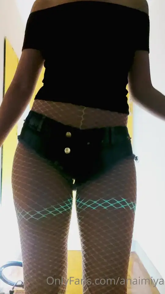 Masked Woman Poses in Glowing Fishnets