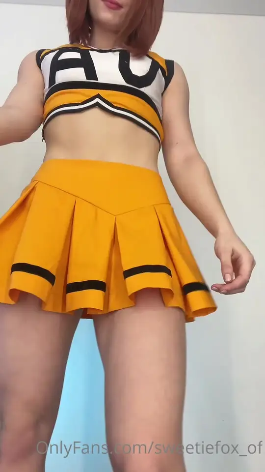 Redhead cheerleader lifts skirt and flashes